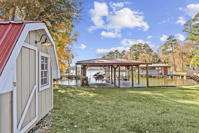 view of dock with a lawn and a water view