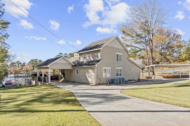 rear view of property featuring central air condition unit and a lawn