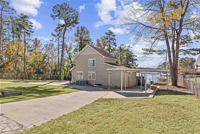 back of property featuring central AC, a carport, and a yard