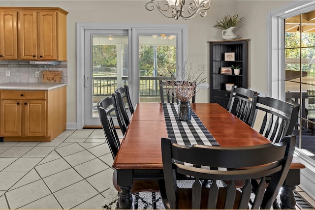 tiled dining room with a notable chandelier and plenty of natural light