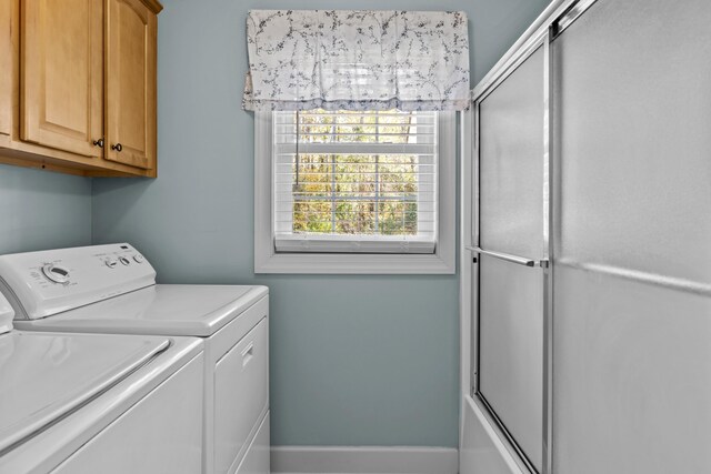 washroom featuring washer and clothes dryer and cabinets