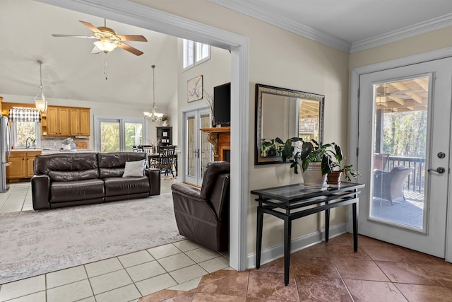 living room with ornamental molding, ceiling fan with notable chandelier, sink, and light tile patterned floors