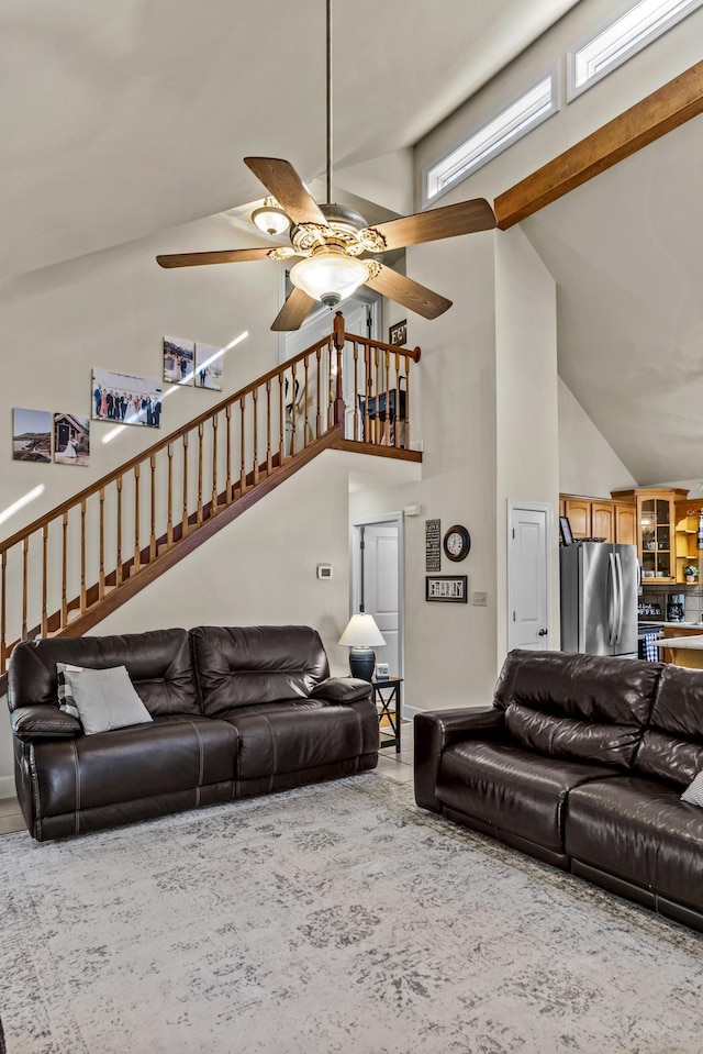 living room featuring beamed ceiling, ceiling fan, and high vaulted ceiling