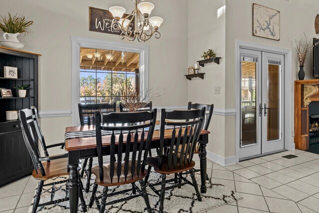 dining space featuring french doors, a notable chandelier, and light tile patterned floors