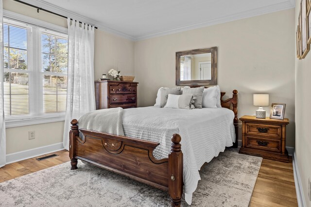 bedroom featuring ornamental molding and light wood-type flooring