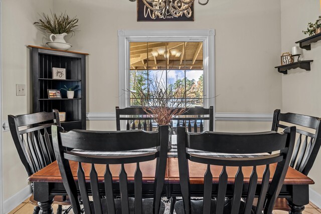 dining area featuring tile patterned floors and an inviting chandelier