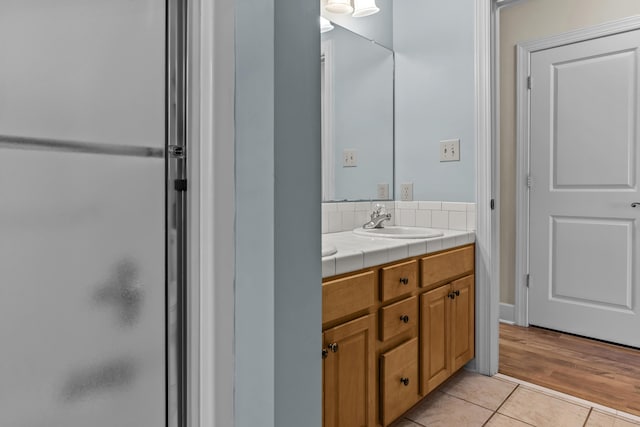 bathroom featuring tile patterned flooring, vanity, and a shower with shower door