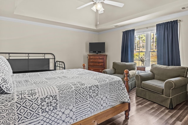 bedroom featuring ornamental molding, a raised ceiling, and hardwood / wood-style floors