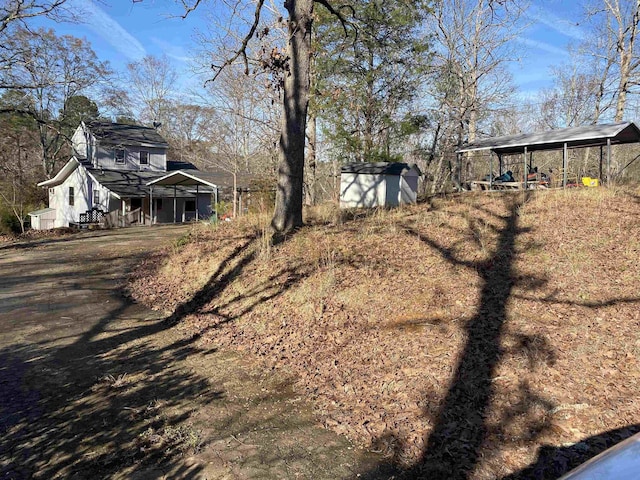 view of yard with a storage shed and a carport