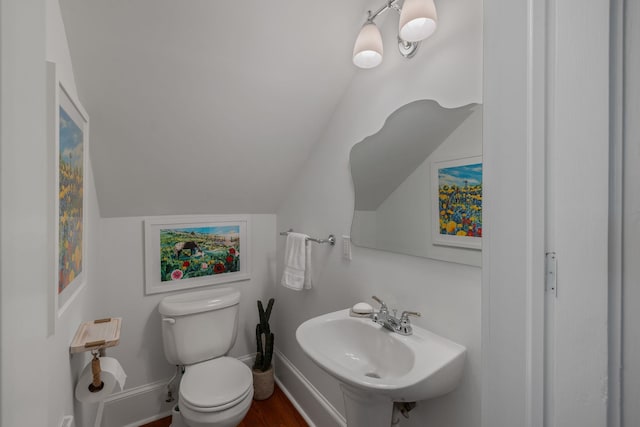 406 Madison Ave, Eatonton, GA 31024 - bathroom with a sink, toilet, vaulted ceiling, baseboards, and wood finished floors