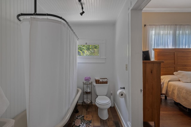 406 Madison Ave, Eatonton, GA 31024 - full bathroom featuring wood finished floors, toilet, shower / bathtub combination with curtain, and rail lighting