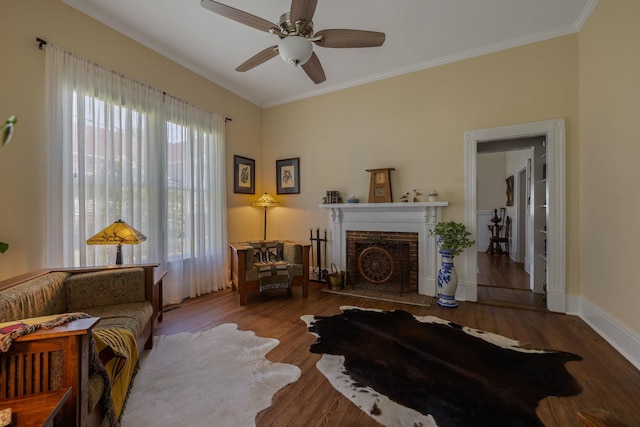 406 Madison Ave, Eatonton, GA 31024 - living area with a ceiling fan, crown molding, a brick fireplace, wood finished floors, and baseboards