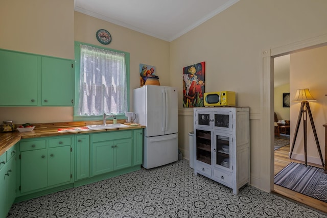 406 Madison Ave, Eatonton, GA 31024 - kitchen featuring freestanding refrigerator, a sink, ornamental molding, light flooring, and green cabinetry