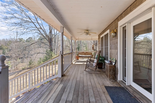 wooden terrace with ceiling fan and covered porch