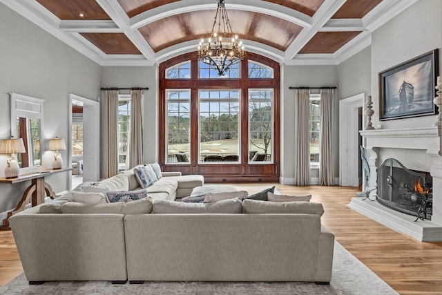 living room featuring coffered ceiling, a notable chandelier, beamed ceiling, and light wood-type flooring