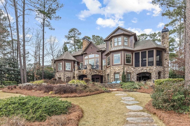 back of property with a sunroom and a lawn