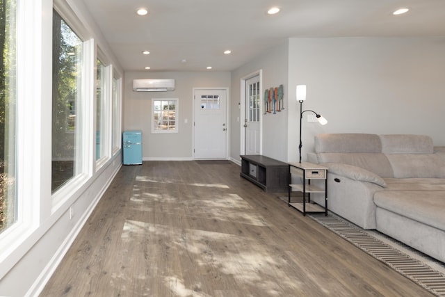 living room with hardwood / wood-style floors and a wall unit AC