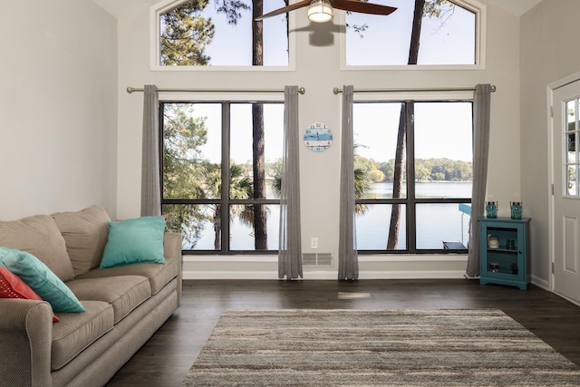 living room with a water view, plenty of natural light, and dark hardwood / wood-style floors