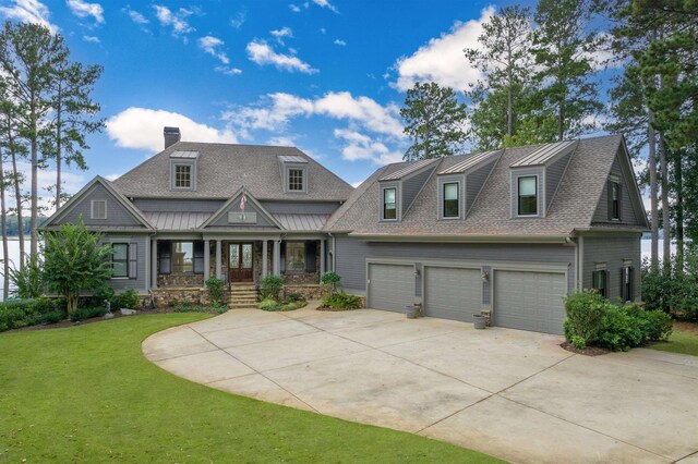 view of front of property with a garage, a front lawn, and covered porch