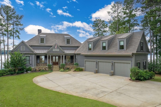 view of front of property with a garage, a front lawn, and covered porch