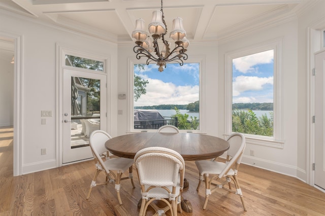 dining space with a water view, coffered ceiling, a notable chandelier, and light hardwood / wood-style flooring