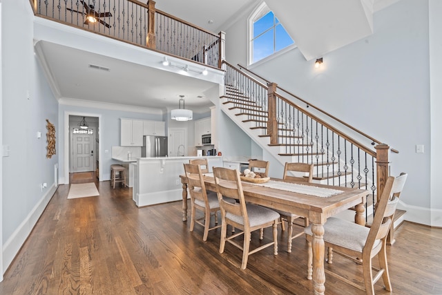 112-UNIT309 Indian Summer Path, Eatonton, GA 31024 - dining space featuring stairway, a towering ceiling, dark wood-type flooring, crown molding, and baseboards