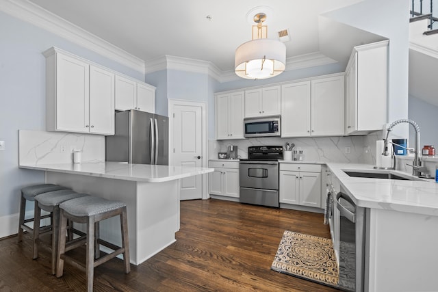 112-UNIT309 Indian Summer Path, Eatonton, GA 31024 - kitchen with stainless steel appliances, a sink, a peninsula, white cabinetry, and ornamental molding
