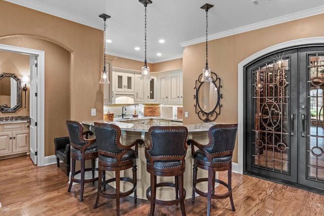 1031 Sugar Run, Greensboro, GA 30642 - bar with light wood-style flooring, a sink, hanging light fixtures, ornamental molding, and baseboards