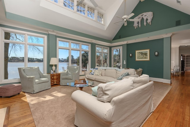 living room with hardwood / wood-style floors, a ceiling fan, visible vents, high vaulted ceiling, and a water view