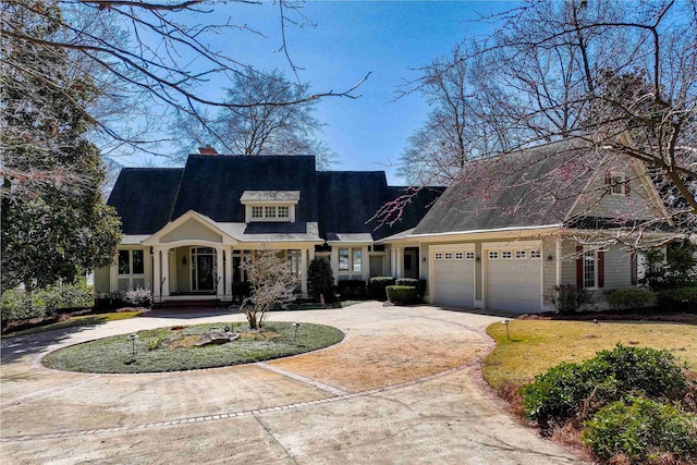 cape cod home featuring a garage, driveway, and a chimney