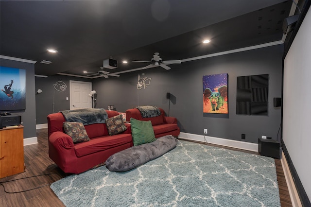 home theater room with a ceiling fan, wood finished floors, baseboards, recessed lighting, and ornamental molding