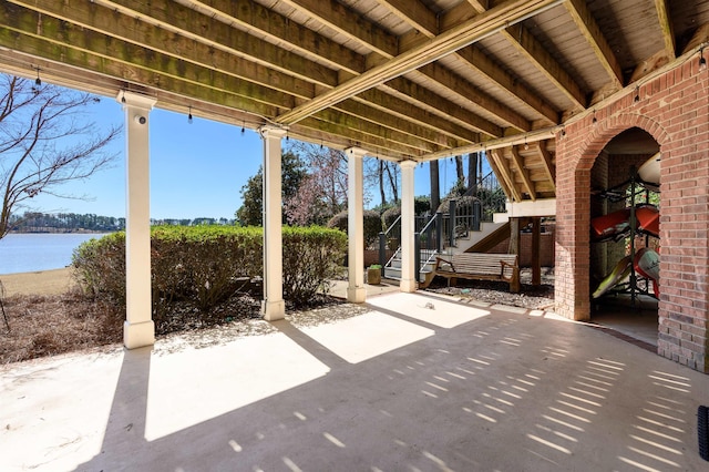 view of patio featuring stairway and a water view