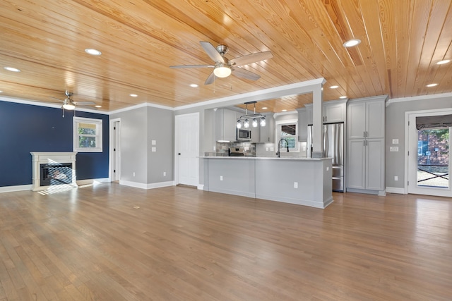 unfurnished living room featuring sink, ceiling fan, crown molding, wooden ceiling, and light wood-type flooring