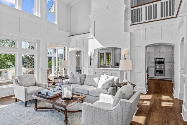 1140 Plantation Point Dr, Greensboro, GA 30642 - living area featuring a decorative wall, arched walkways, dark wood-style floors, and a towering ceiling