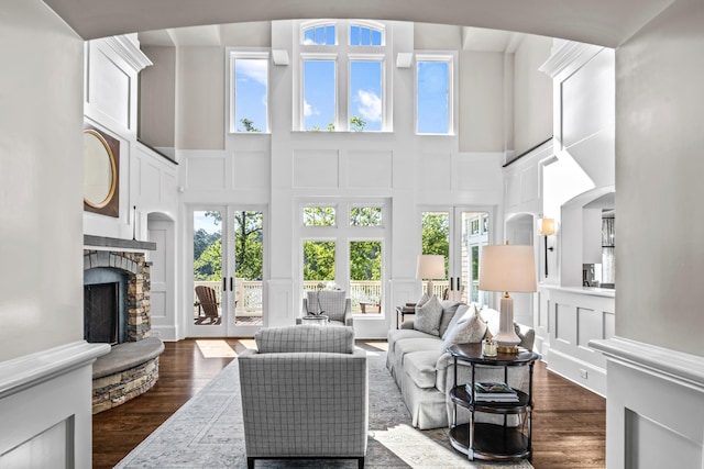 1140 Plantation Point Dr, Greensboro, GA 30642 - living area featuring a fireplace, a decorative wall, french doors, a towering ceiling, and dark wood-type flooring