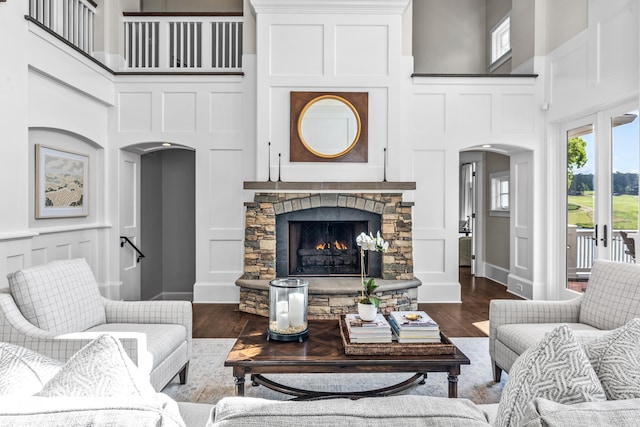 1140 Plantation Point Dr, Greensboro, GA 30642 - living area with arched walkways, a towering ceiling, a decorative wall, and dark wood-style floors