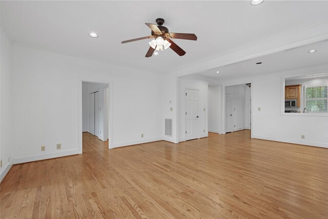 unfurnished living room featuring crown molding, ceiling fan, and light hardwood / wood-style flooring