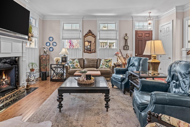 living room with ornamental molding, a fireplace, and wood finished floors