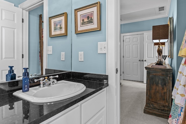 bathroom featuring ornamental molding, visible vents, and vanity