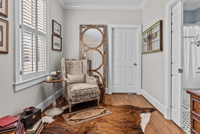 living area featuring crown molding, baseboards, and wood finished floors