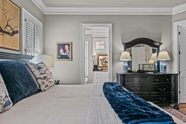 bedroom featuring ornamental molding, ensuite bath, and wood finished floors