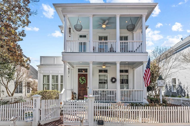 neoclassical home with a ceiling fan, covered porch, fence, and a balcony