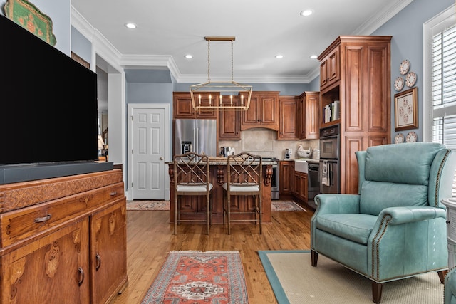 kitchen with a breakfast bar area, stainless steel appliances, open floor plan, brown cabinetry, and crown molding