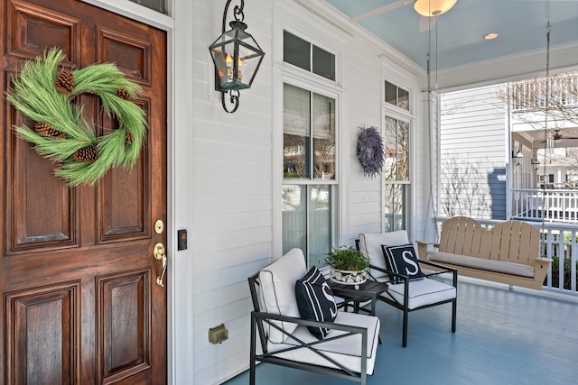 doorway to property featuring covered porch and ceiling fan