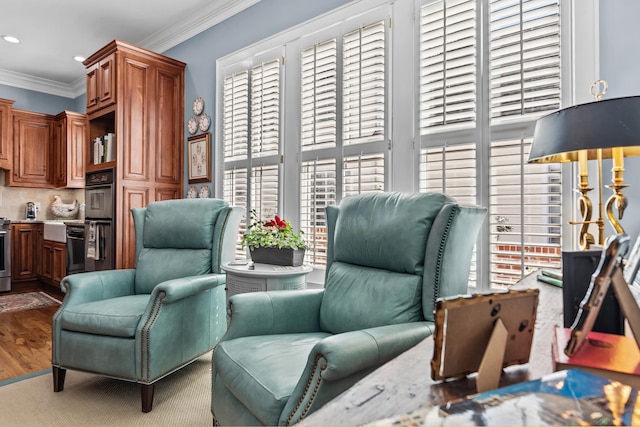 sitting room featuring ornamental molding, wood finished floors, and recessed lighting