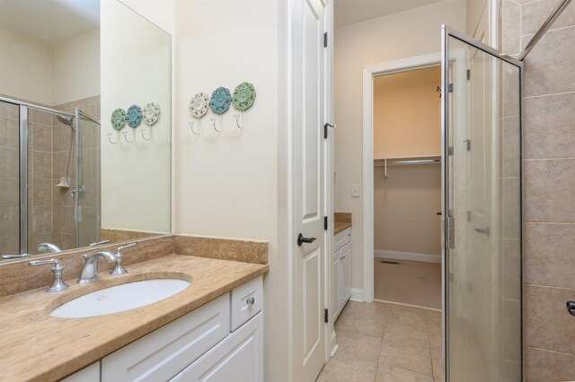 bathroom with an enclosed shower, vanity, and tile patterned floors