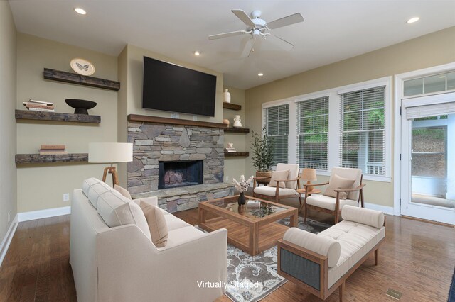 living room with hardwood / wood-style flooring, ceiling fan, and a fireplace