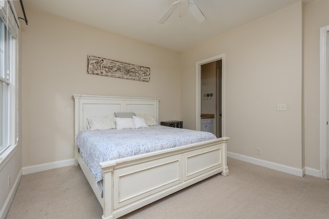 carpeted bedroom featuring ceiling fan and ensuite bath