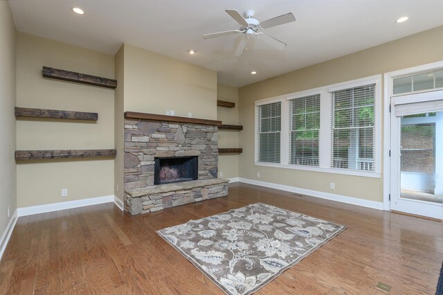 living room with ceiling fan, a fireplace, and wood-type flooring