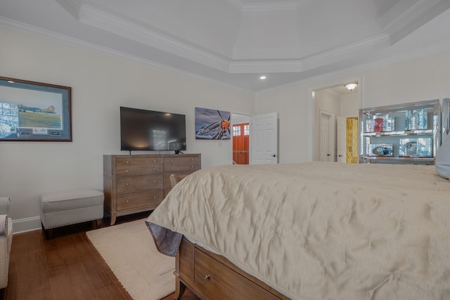 bedroom with crown molding, dark hardwood / wood-style flooring, and a raised ceiling